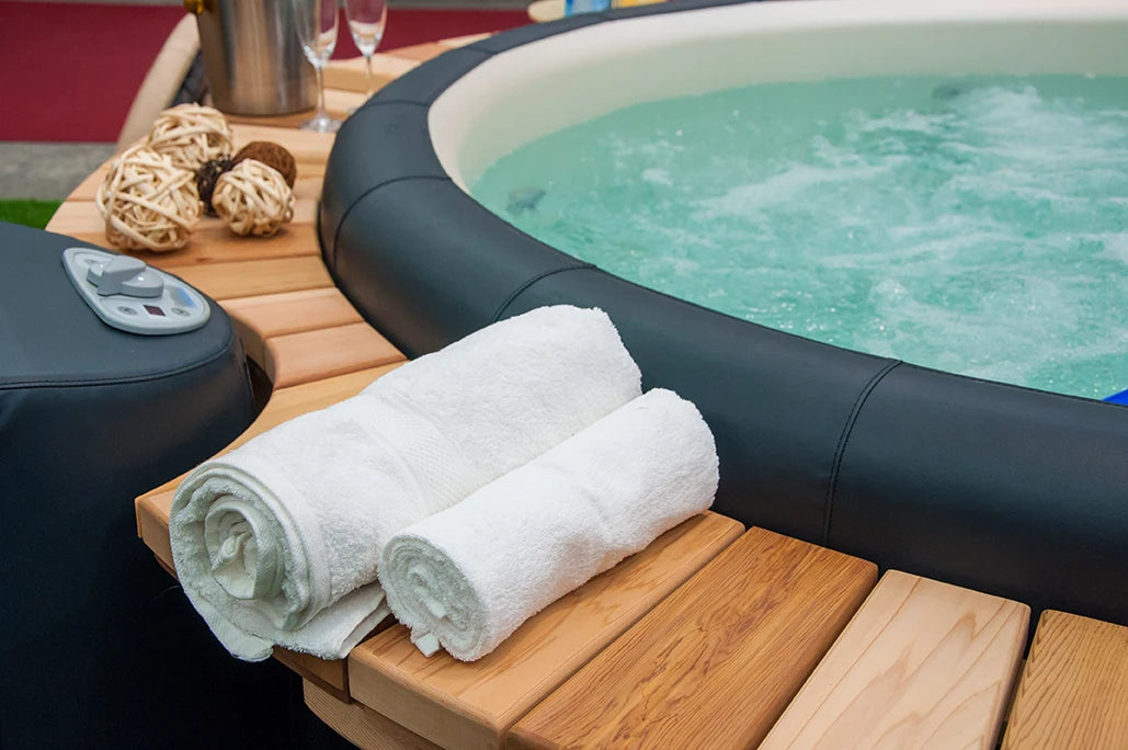 Clean white towels next to an inviting outdoor hot tub setup