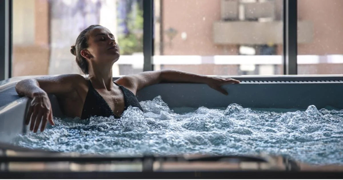 Woman in a black swimsuit relaxing in a modern indoor hot tub